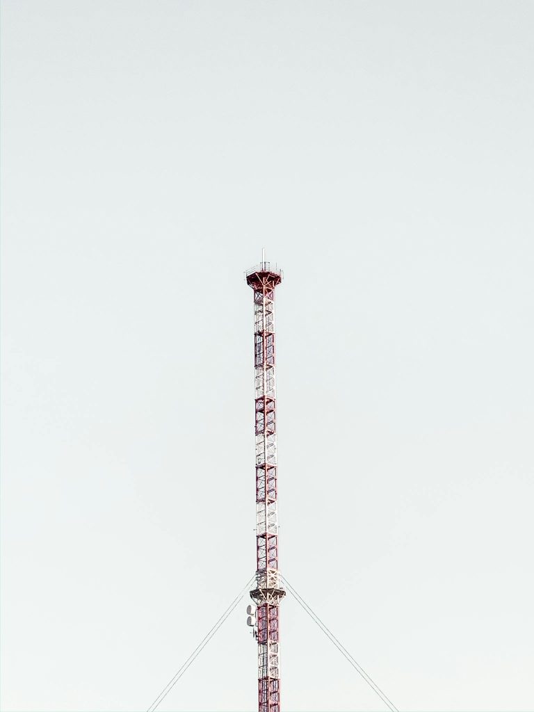Telecom tower located under gray sky
