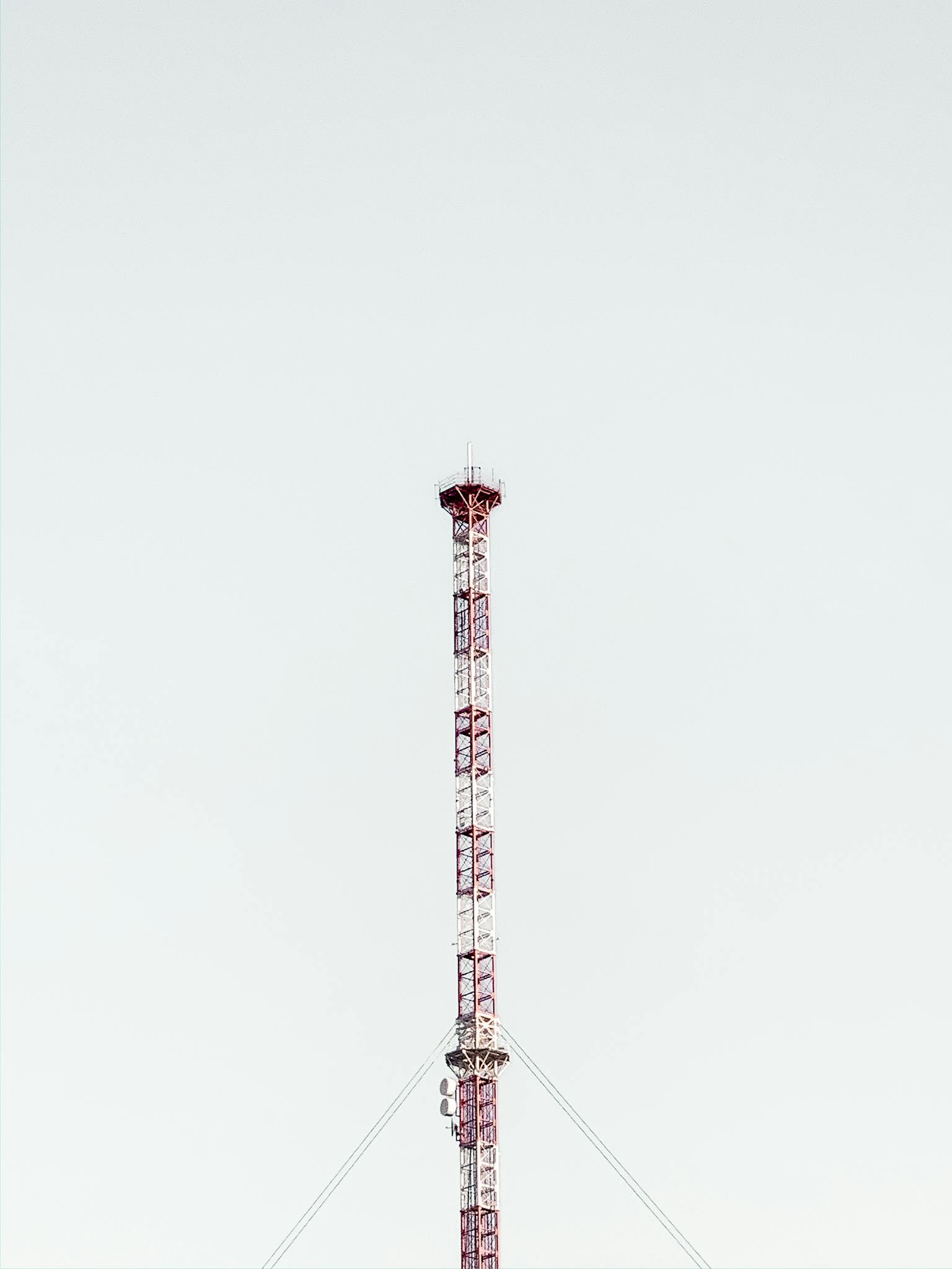 Telecom tower located under gray sky